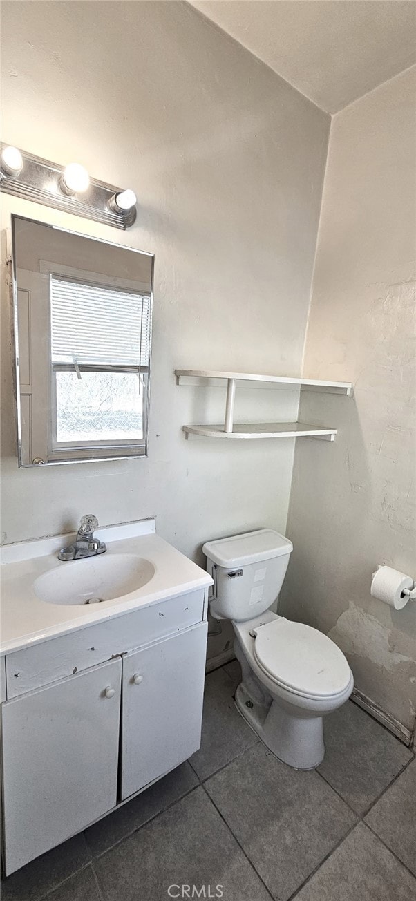 bathroom featuring tile patterned floors, vanity, and toilet