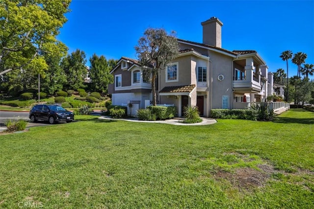 view of side of property featuring a lawn, a chimney, a tile roof, and stucco siding