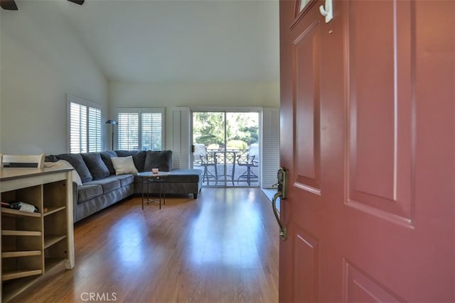 interior space with ceiling fan, high vaulted ceiling, plenty of natural light, and wood finished floors