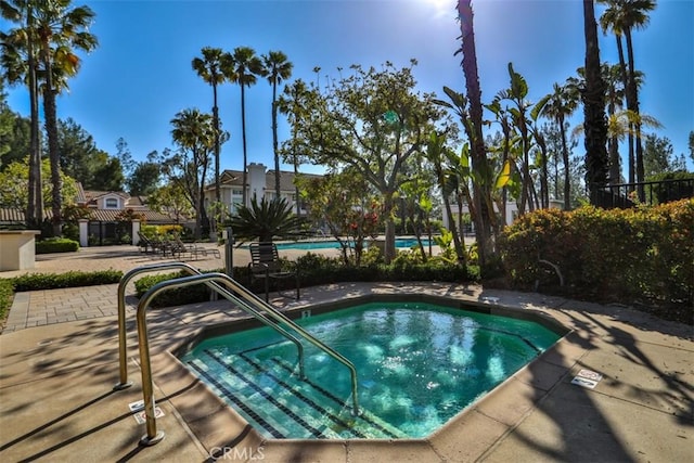 view of pool featuring fence and a community hot tub