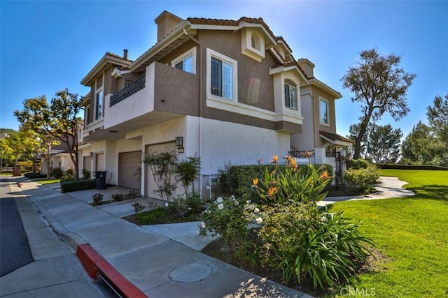 view of home's exterior with a balcony, stucco siding, concrete driveway, an attached garage, and a yard
