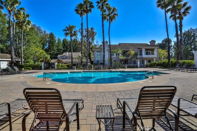 community pool featuring fence and a patio