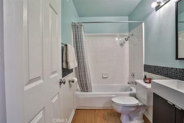bathroom featuring vanity, shower / bath combo, toilet, and wood finished floors