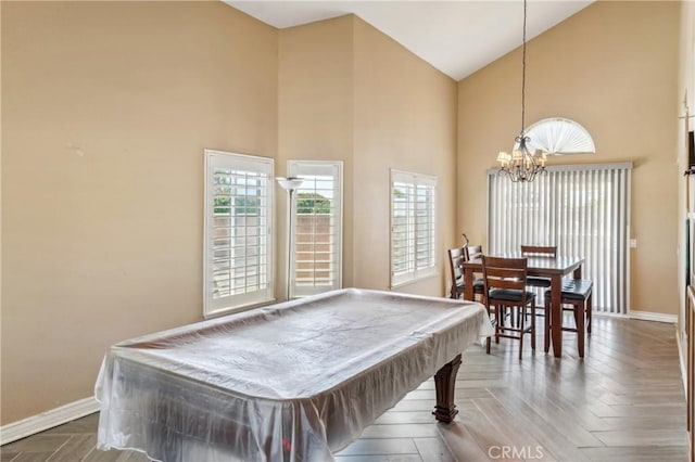 game room featuring pool table, high vaulted ceiling, a notable chandelier, and baseboards