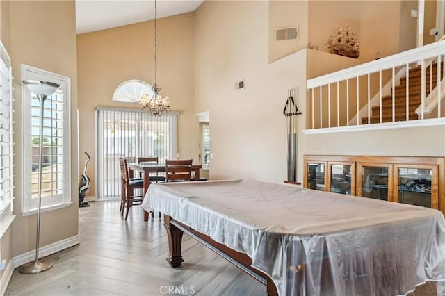 game room with a towering ceiling, baseboards, and visible vents