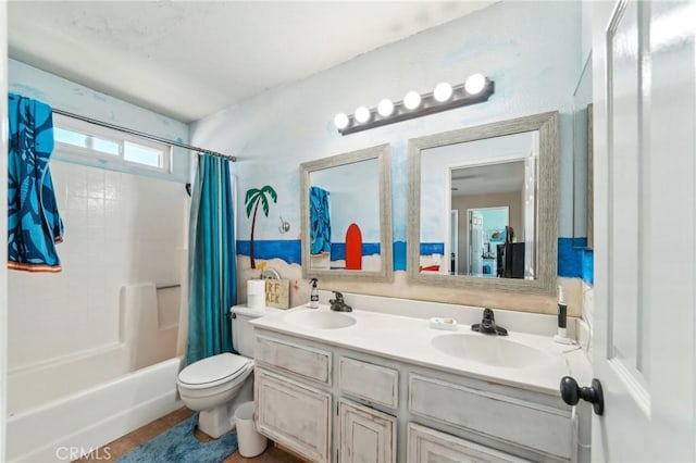 bathroom featuring double vanity, toilet, a sink, and shower / bath combo