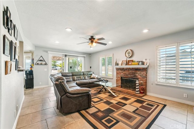 living room featuring light tile patterned flooring, ceiling fan, a fireplace, recessed lighting, and baseboards