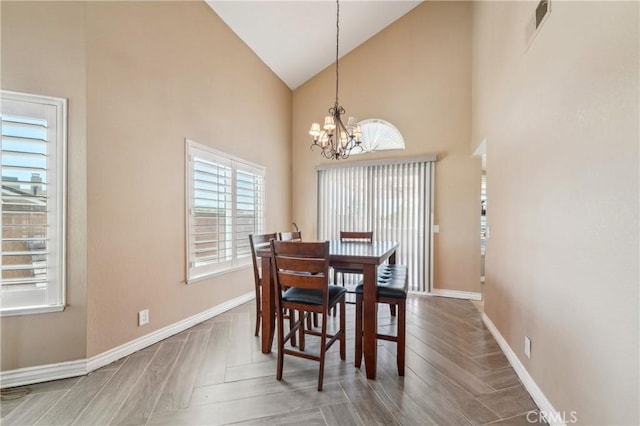 dining area featuring an inviting chandelier, high vaulted ceiling, baseboards, wood finished floors, and visible vents