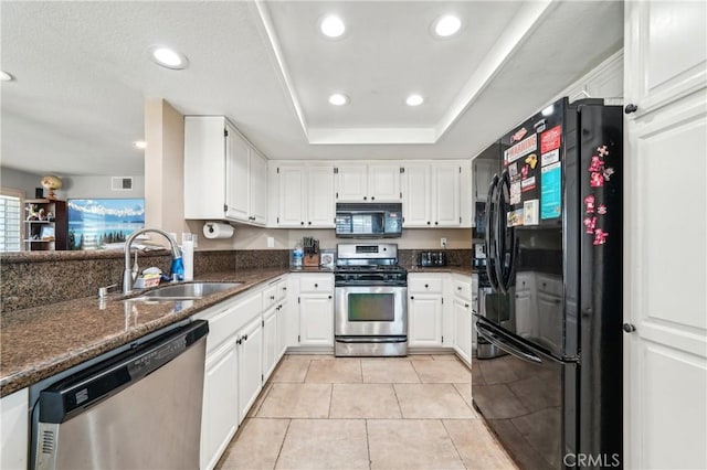 kitchen featuring a sink, dark stone countertops, white cabinetry, visible vents, and black appliances