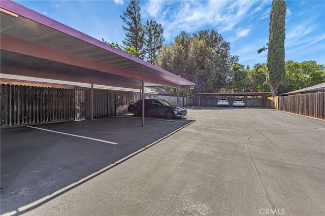 covered parking lot featuring fence