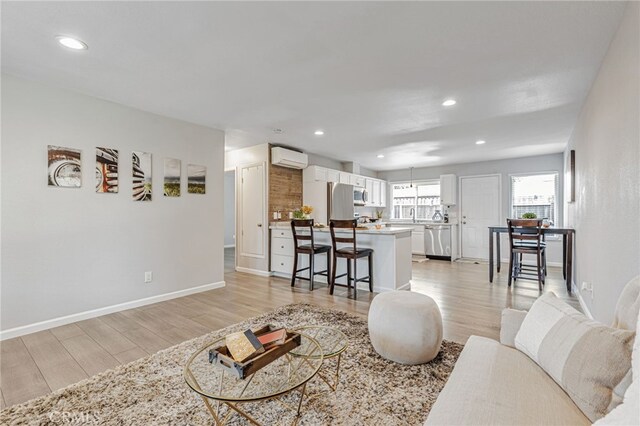 6633 Plymouth Rd, Stockton, CA 95207 - living area featuring a wall mounted AC, light wood-style floors, recessed lighting, and baseboards