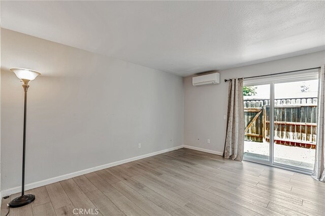 6633 Plymouth Rd, Stockton, CA 95207 - spare room with a wall unit AC, wood finished floors, and baseboards