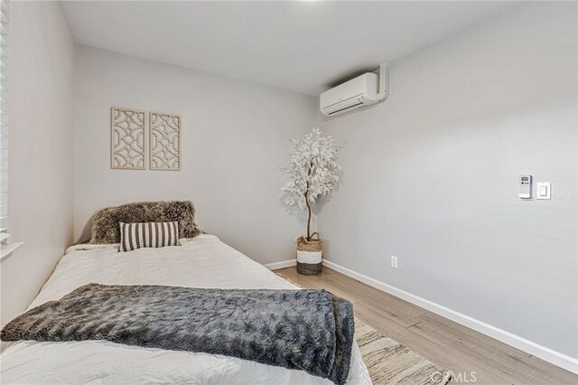 6633 Plymouth Rd, Stockton, CA 95207 - bedroom with a wall unit AC, wood finished floors, and baseboards