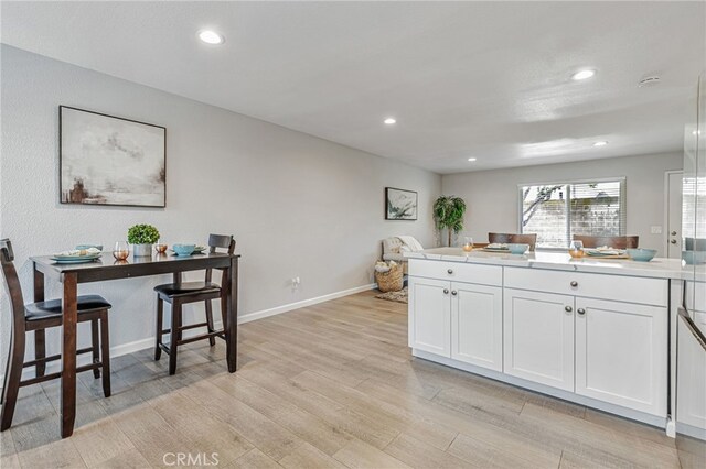 6633 Plymouth Rd, Stockton, CA 95207 - kitchen featuring white cabinets, light wood-style floors, recessed lighting, light countertops, and baseboards
