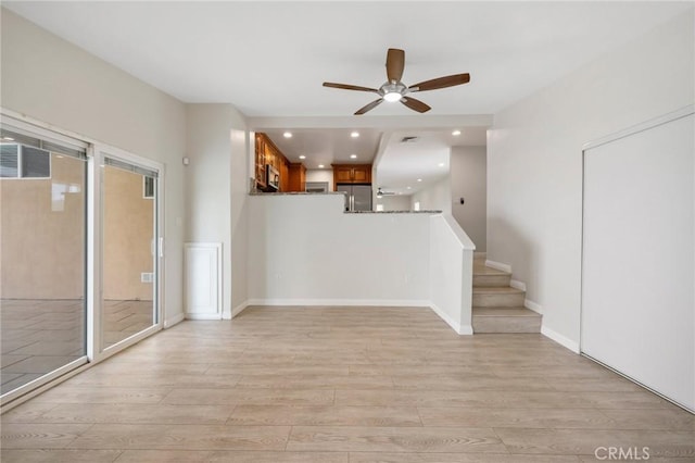 unfurnished living room with ceiling fan, light wood-type flooring, stairs, and visible vents