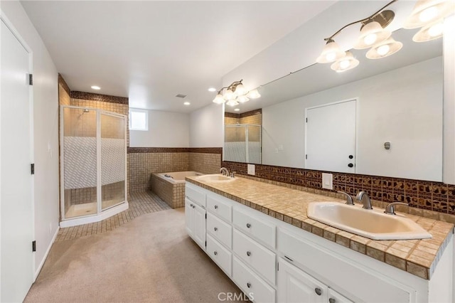 bathroom featuring a sink, double vanity, recessed lighting, a garden tub, and a stall shower