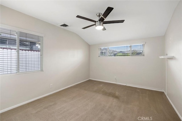 spare room featuring visible vents, ceiling fan, carpet, and lofted ceiling