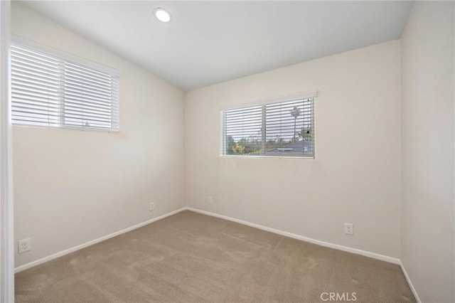 unfurnished room featuring baseboards and carpet