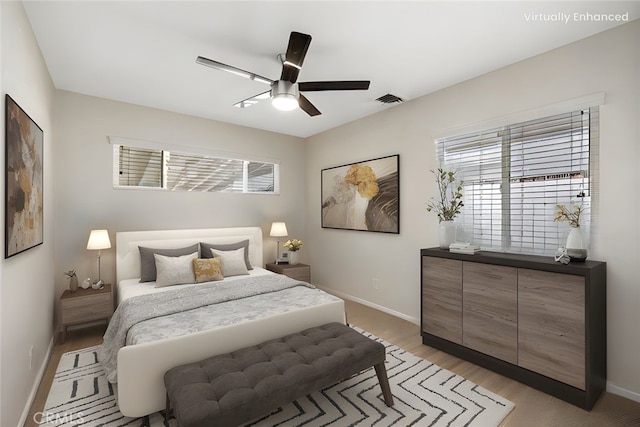 bedroom with baseboards, a ceiling fan, light wood-style flooring, and visible vents