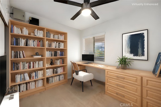 carpeted home office with ceiling fan, baseboards, and built in study area
