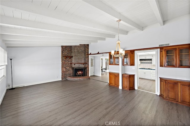 kitchen featuring beam ceiling, dark wood finished floors, brown cabinetry, visible vents, and glass insert cabinets
