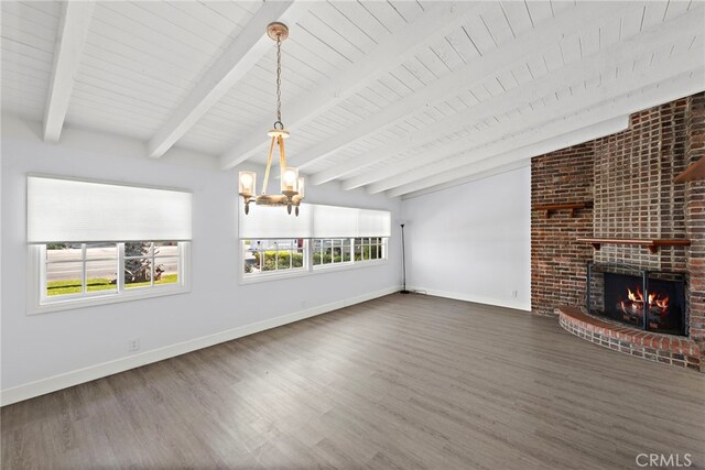 unfurnished living room with an inviting chandelier, baseboards, and wood finished floors