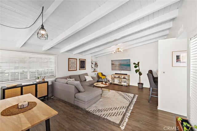 living room with baseboards, beam ceiling, and wood finished floors