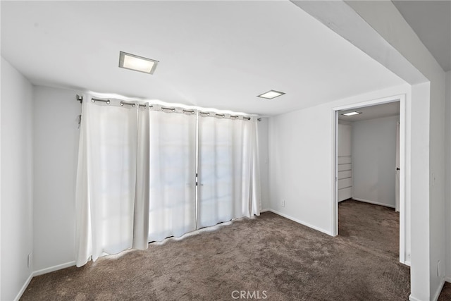 unfurnished bedroom with baseboards and carpet flooring