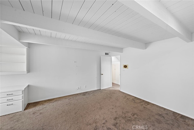 unfurnished living room with beamed ceiling, carpet, and wood ceiling
