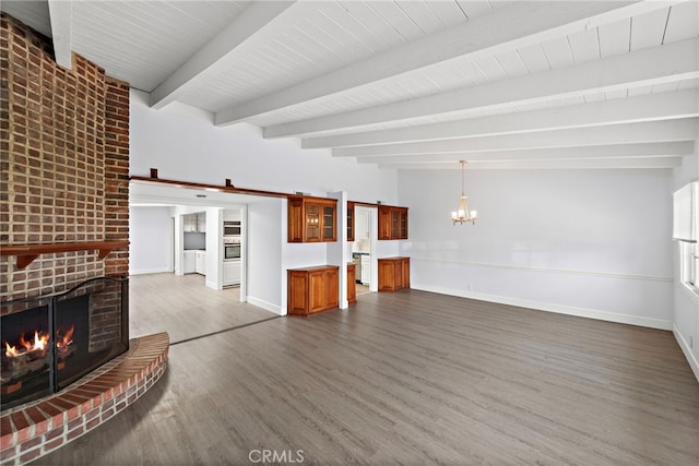 unfurnished living room featuring baseboards, dark wood finished floors, a brick fireplace, and beam ceiling