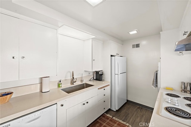 kitchen featuring white cabinets, a sink, white appliances, dark wood finished floors, and visible vents