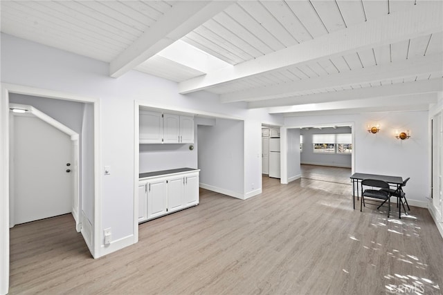 living area featuring light wood-style floors, baseboards, and beam ceiling
