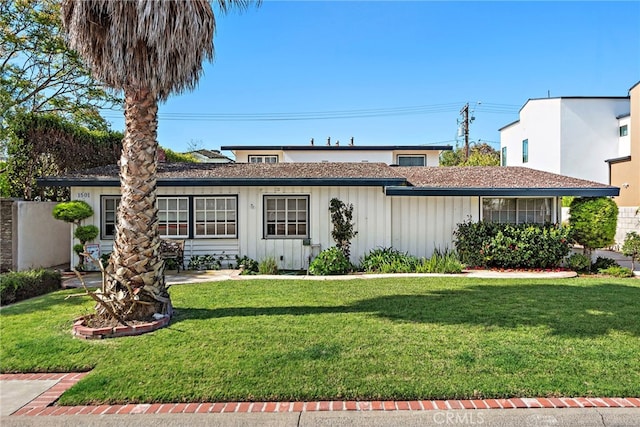 ranch-style home featuring board and batten siding and a front lawn