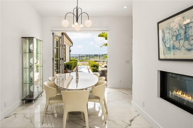 21 Alexa Ln, Ladera Ranch, CA 92694 - dining room with marble finish floors, recessed lighting, a glass covered fireplace, and a chandelier