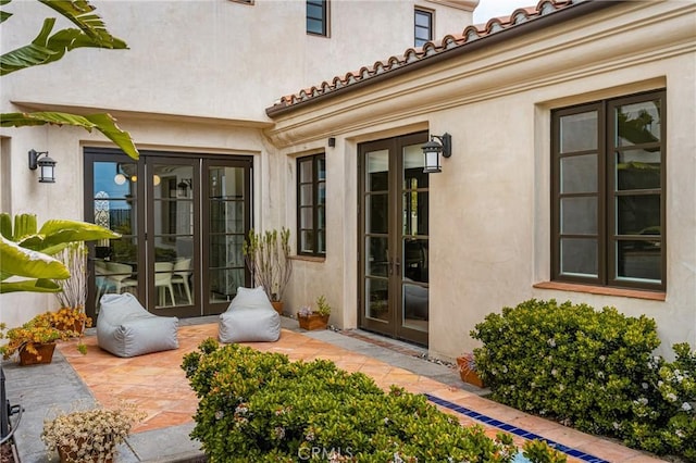 21 Alexa Ln, Ladera Ranch, CA 92694 - view of exterior entry with french doors, stucco siding, a patio, and a tile roof