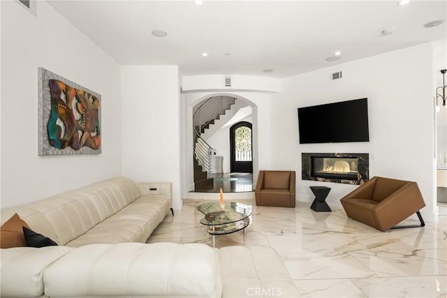 21 Alexa Ln, Ladera Ranch, CA 92694 - living area featuring arched walkways, recessed lighting, marble tiled flooring, and a glass covered fireplace