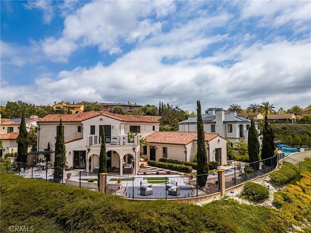21 Alexa Ln, Ladera Ranch, CA 92694 - rear view of property with a balcony, a patio area, a fenced backyard, stucco siding, and a residential view