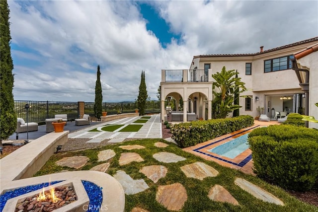 21 Alexa Ln, Ladera Ranch, CA 92694 - rear view of house featuring a balcony, a patio, a fire pit, and stucco siding