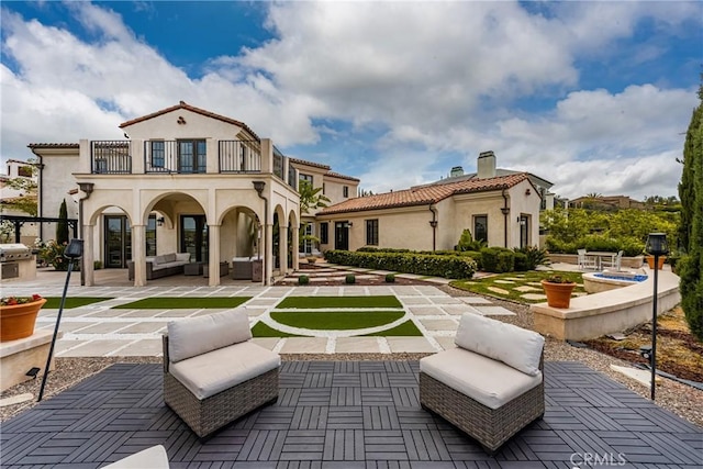 21 Alexa Ln, Ladera Ranch, CA 92694 - back of property with a balcony, a patio, outdoor lounge area, a chimney, and stucco siding