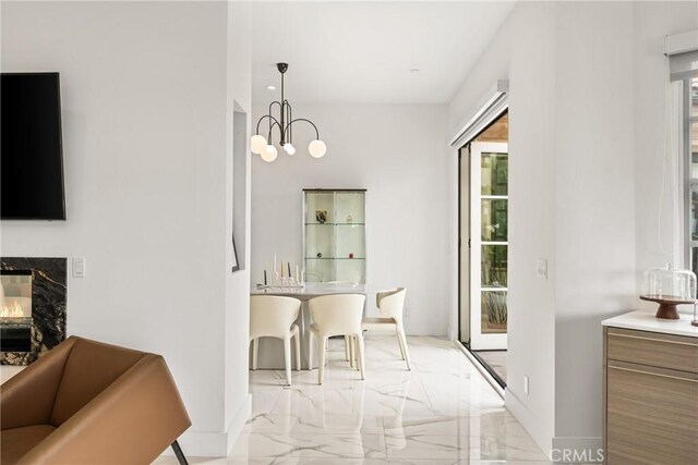 21 Alexa Ln, Ladera Ranch, CA 92694 - dining area featuring light marble finish flooring, healthy amount of natural light, a chandelier, and a premium fireplace