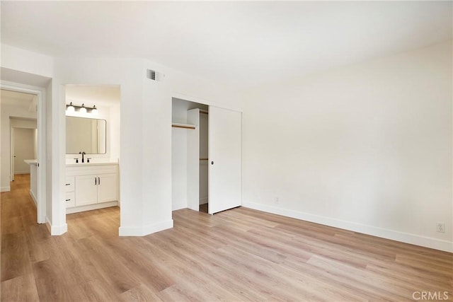 unfurnished bedroom with baseboards, a closet, and light wood-style flooring