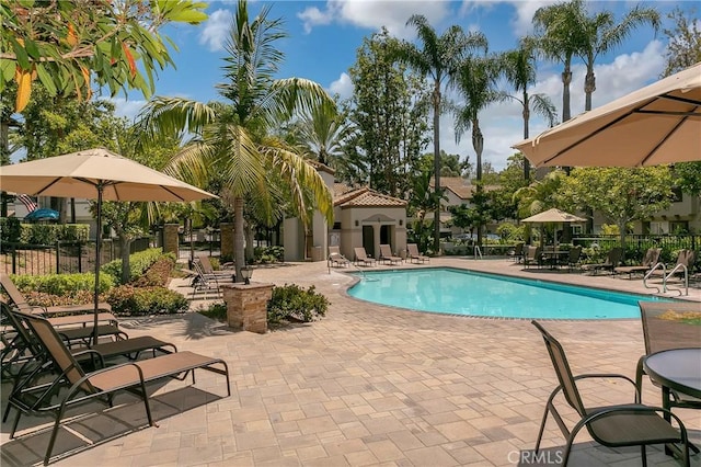community pool with a patio and fence