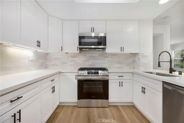 kitchen featuring a sink, white cabinetry, appliances with stainless steel finishes, and light countertops