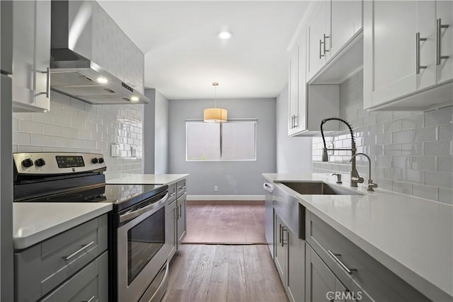 5414 Newcastle Ave Unit 66, Encino, CA 91316 - kitchen with stainless steel appliances, wall chimney range hood, light countertops, backsplash, and dark wood finished floors
