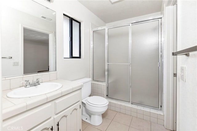 full bathroom featuring vanity, toilet, tile patterned floors, visible vents, and a stall shower