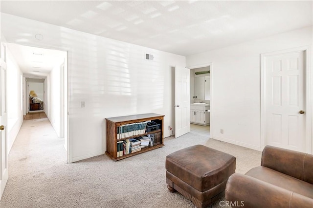living room with baseboards, light colored carpet, and visible vents