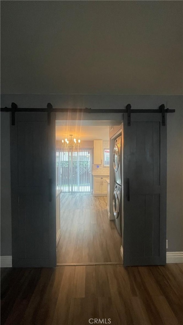 1045 Peach Ave Unit 17, El Cajon, CA 92021 - hallway featuring baseboards, stacked washer / drying machine, a barn door, and wood finished floors