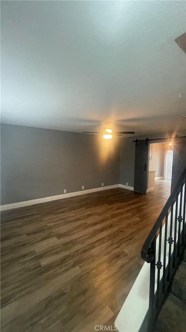 1045 Peach Ave Unit 17, El Cajon, CA 92021 - unfurnished room with baseboards, ceiling fan, a barn door, and wood finished floors