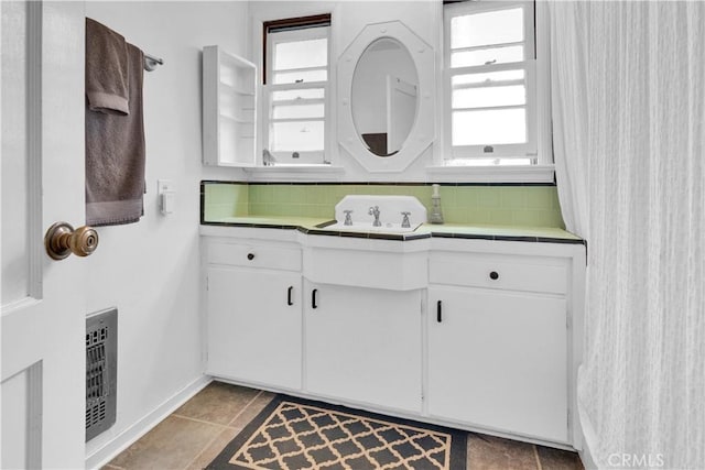 bathroom with decorative backsplash, plenty of natural light, and baseboards