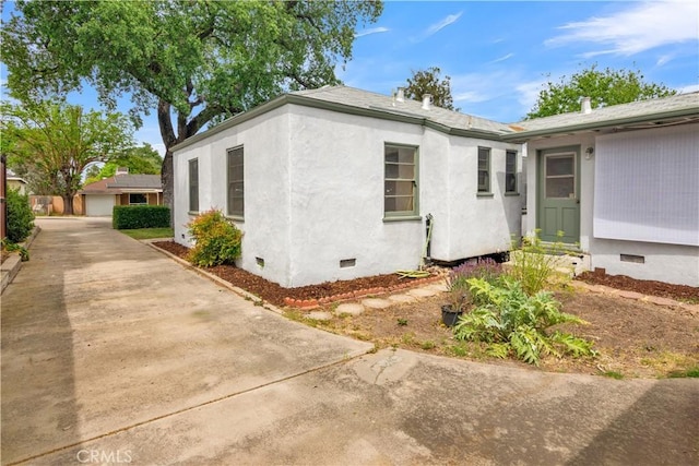view of side of home featuring crawl space and stucco siding